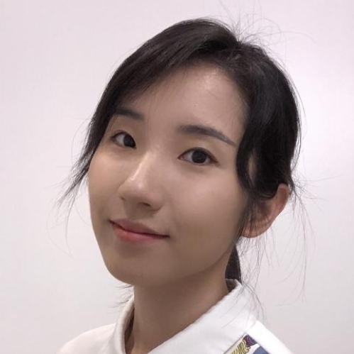 head shot of Asian woman with black hair pulled into a ponytail wearing a white shirt