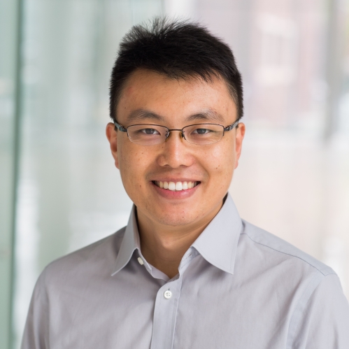 head shot of asian man with short hair and eyeglasses wearing a button down shirt