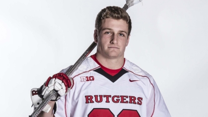 Michael Rexrode dressed in a lacrosse uniform and holding a lacrosse stick