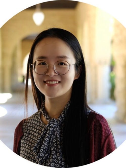Headshot of Chinese woman with long black hair wearing eyeglasses and a blue and white patterned blouse.