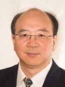 head shot of asian male with eyeglasses wearing a black suit, white shirt, and patterned tie
