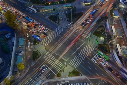 Aerial view of a roadway intersection showing cars moving.