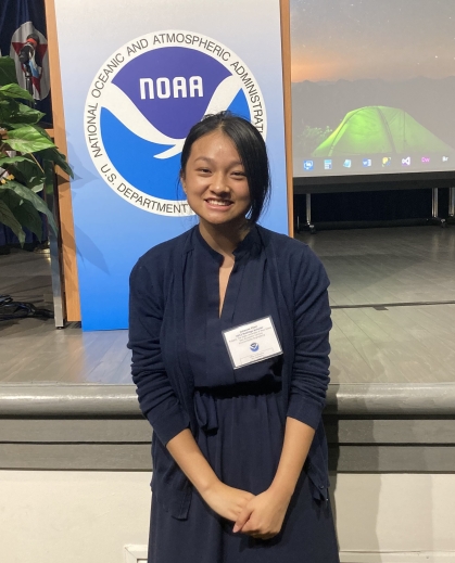 Female Asian college student wearing a navy blue dress and a name tag.