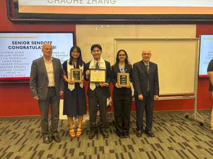 Three students holding awards as they are flanked by two male faculty.