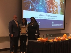 Rutgers students Jingnan Zhao standing between two people and holding an award