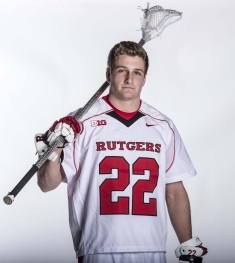 Michael Rexrode dressed in a lacrosse uniform and holding a lacrosse stick